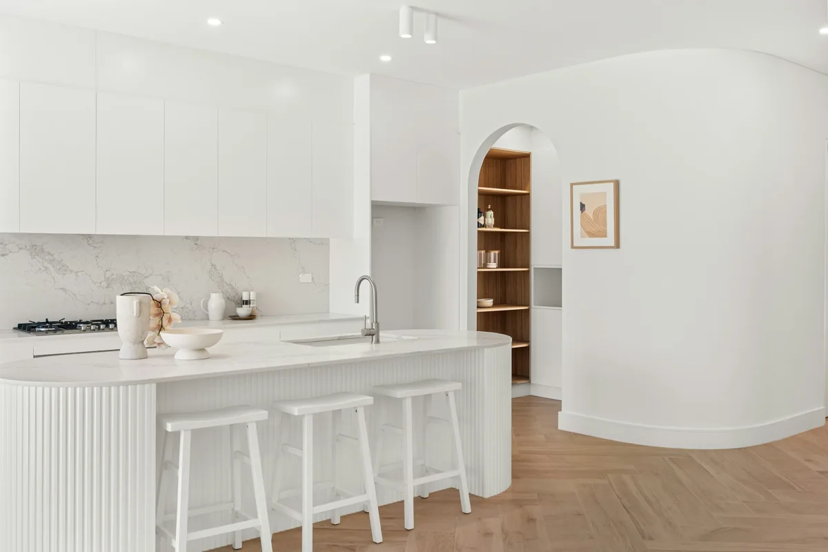 A bright kitchen with a marble island and timber details